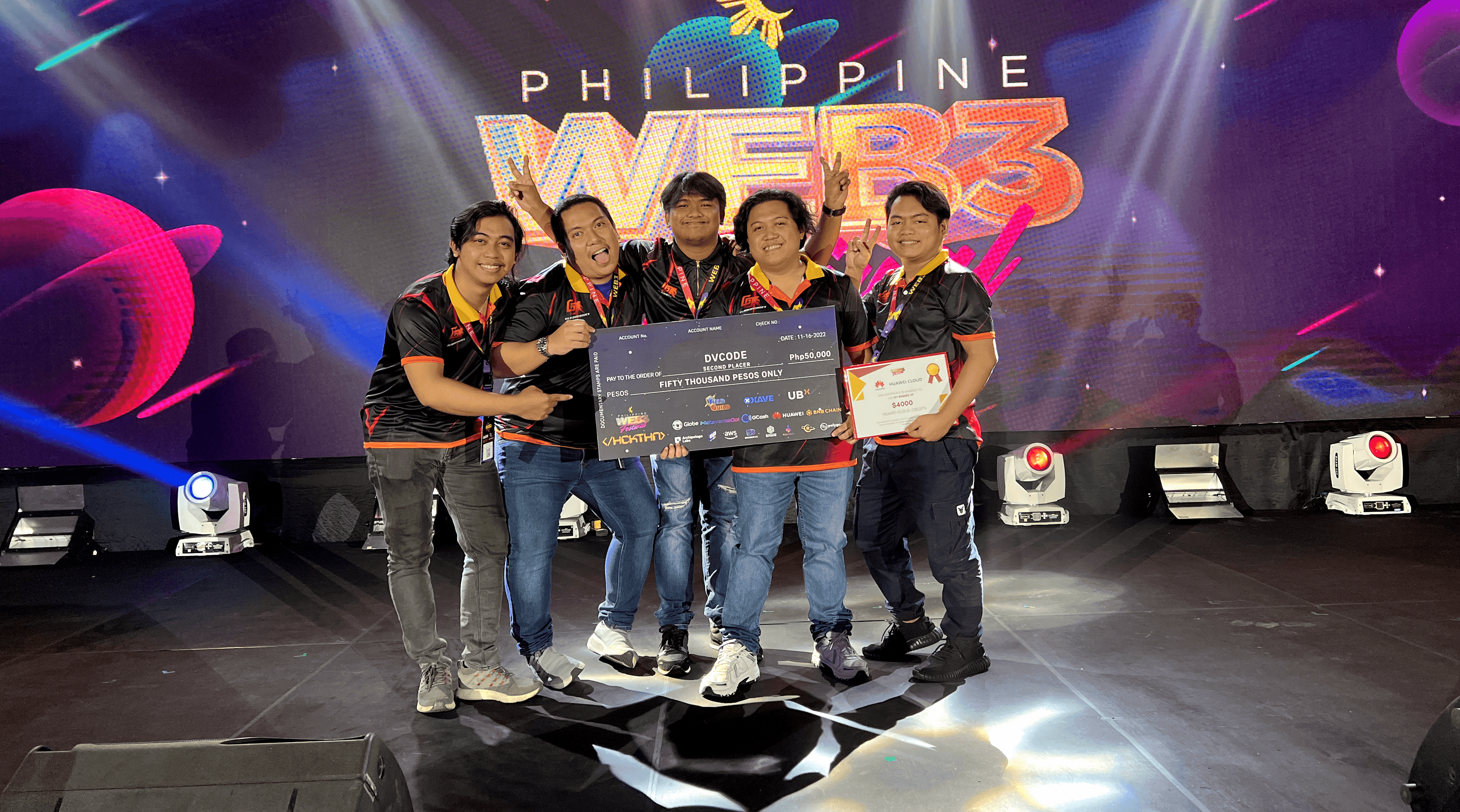 Five members of the DvCode team on stage at the Philippine Web3 Festival hackathon, holding an oversized second-place cheque for fifty thousand pesos.